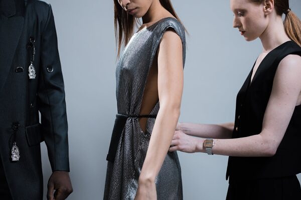 a model getting dressed by the designer