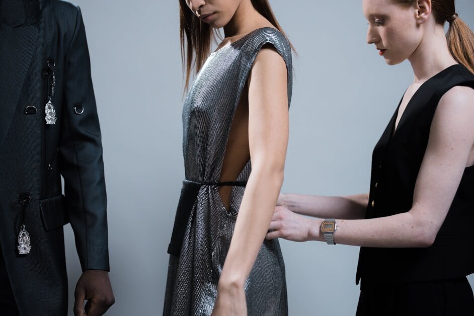 a model getting dressed by the designer